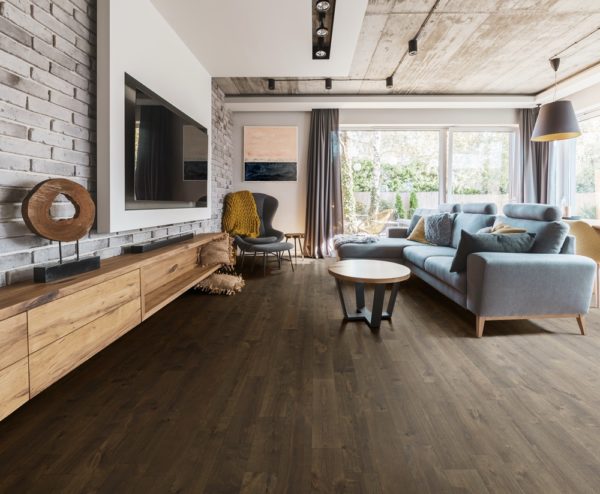 Elegant living room with light wooden floor, grey couch and wing