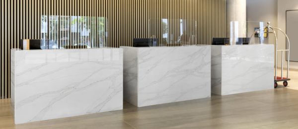 Interior of a hotel lobby with reception desks with transparent coronavirus guards