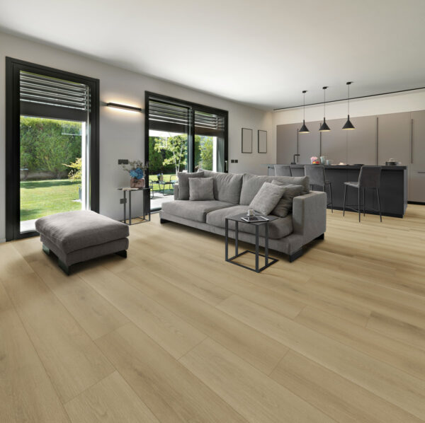 modern living interior in the foreground the gray fabric sofa with its footrest and the carpet on the background there is  the island kitchen